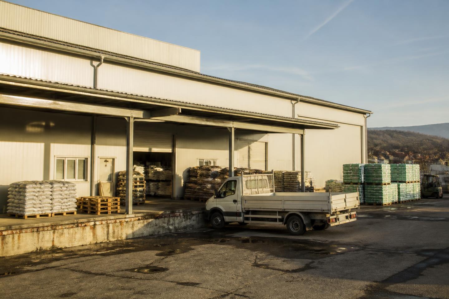 Depozitul de distribuție al companiei, cu rampă de încărcare și paleți